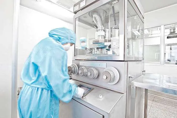 pharmaceutical factory equipment working with unrecognizable technician in blue